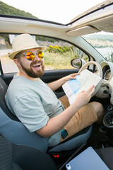 Hipster man looking on location navigation map in car, tourist traveler driving and hold in male hands europe cartography, view and plan tourist way road, trip in transportation cabriolet auto