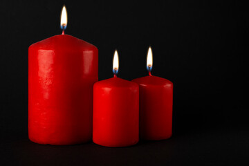 Burning candles isolated on black background