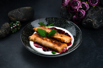 Fried sweet thin pancakes with cottage cheese, cherry jam, sour cream and mint.