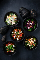 Set of vinaigrette salad, Caesar salad, Greek salad, salad with chicken, lettuce, beans, croutons and salad with boiled beets, arugula, feta cheese and walnuts.