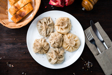 Khinkali with meat, pepper and bread in plate.