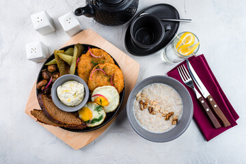 Fried potato pancakes with eggs, mushrooms, pickled cucumbers, onions, bread, sauce, oatmeal with walnuts, peanuts and cup of tea.
