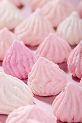 Pink meringue cookies with berry flavor on a pink background