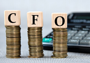 CFO - acronym on wooden cubes on the background of coins and calculator