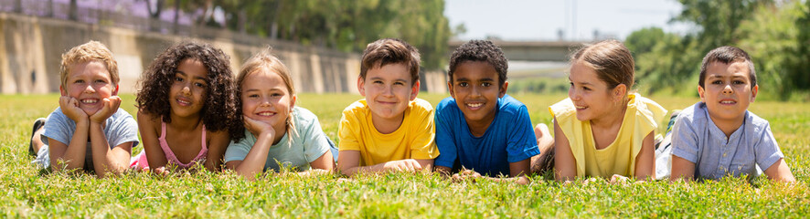 Portrait of smiling children who are posing lying in the park