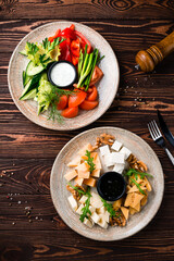 Cheese plate for wine: parmesan, feta, gouda, honey and walnuts with vegetable salad.