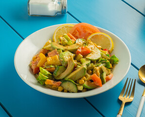Avocado Salad in white plate on blue wood table
