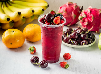Super Mixed Berry Juice with strawberry, blueberry, blackberry, raspberry, cherry and cranberry raw fruits served in disposable glass isolated on background top view taiwan food