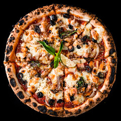 Italian kitchen pizza with salmon, onion, olives, cheese, basil, tomato sauce, lime and spices isolated on black.