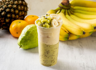 Kiwi Banana milkshake served in disposable glass isolated on background top view taiwan food
