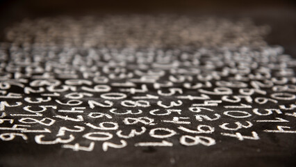 Muchos números escritos a mano con tiza en una pizarra, vistos en perspectiva	