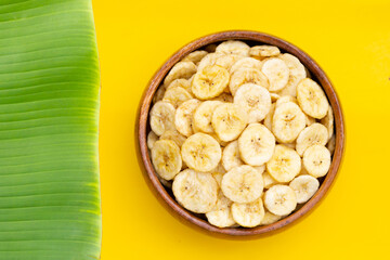 Banana slice chips on yellow background.