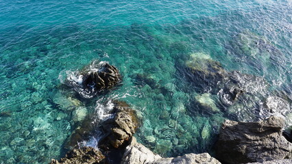 Crystal clear ocen water with volcanic rocks visible on the bottom