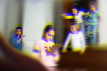 Focused tween children trying to solve riddles in quest room. Toned image with visual effect