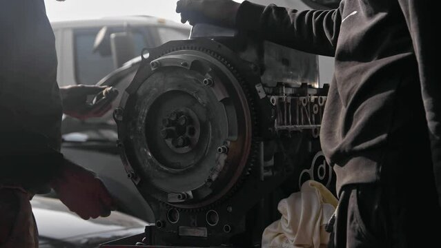 Tightening the Flywheel Gear of the Old Car Engine in the Repair Shop Footage.