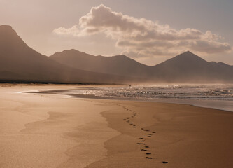 Scenic view on the beach Cofete, ocean water and footprints in the sand on Fuerteventura, Spain - Canary Islands