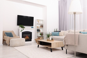 Stylish living room interior with cozy sofa, table, TV set and fireplace