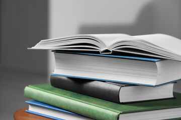 Stack of hardcover books on wooden table, closeup