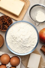 Flat lay composition with flour and different ingredients on white wooden table. Yeast pastry