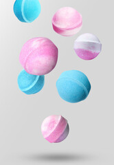 Many different bath bombs falling on light grey background