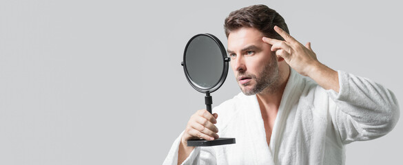 Banner with copy space of man touching chin and skin. Handsome man touching face in front of the mirror in bath. Perfect skin. Man cosmetic, skin treatment. Hygiene and skin care male face.