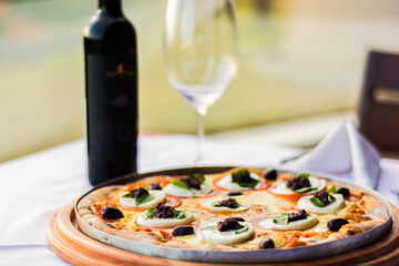 Pizza suculenta servida acompanhada de um vinho