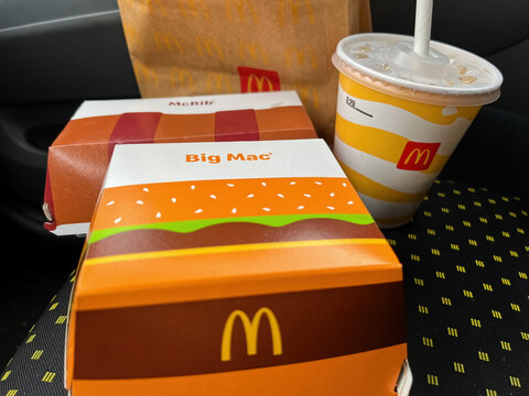 GERMANY - APR 06, 2023: McDonald's Big Mac, Drink  and McRib as a quick on-the-go snack in the car