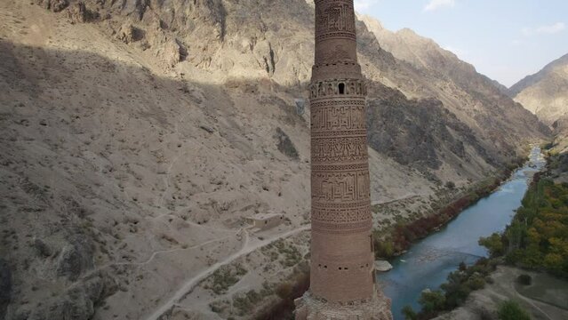 Rising aerial push-out of Minaret of Jam by river in Afghanistan