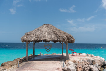 Palm leaf palapa on the shore of a beach to protect from the sun on the island of Curaçao. Netherlands Antilles.
