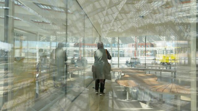 Arab female worker with hijab cleaning the floor of the bus station waiting room