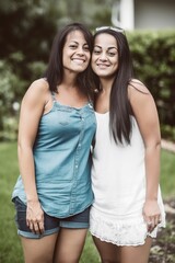 Obraz premium Smiling mid aged hispanic lesbian couple posing at their backyard. Generative AI 