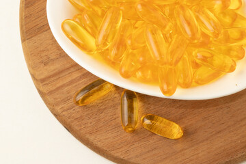 Fish oil capsules in a bowl top view. Selective focus.