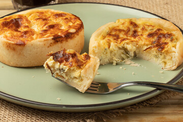 Tasting delicious quiche on green plate. Selective focus.