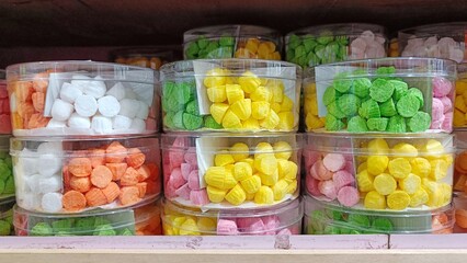 Colorful cakes like candies in plastic jars on display in a cake shop
