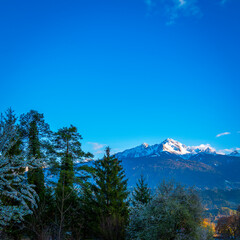 Sunrise over the Alps Northern Range covered with snow and flowers in bloom in Innsbruck, Tyrol, the western Austria