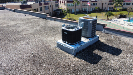 Air conditioning units on apartment roof top for central air for condos in Florida from aerial drone