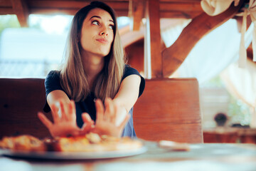 Unhappy Woman refusing to Eat her Pizza Dish in a Restaurant. Disgruntled customer not liking the meal sending it back
 - obrazy, fototapety, plakaty