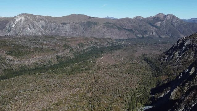 aerial view of a valley surrounded by mountains with trails of volcanic rock