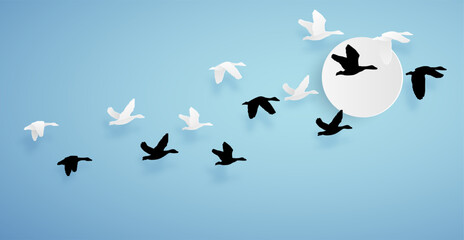 duck or teal birds flying to the sky on blue background and sun. paper art concept.