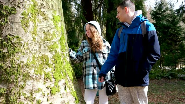 stanley park teenagers walking taking pictures fooling around looking at trees chatting autumn spring cool weather tourists backpacks phones fun first date walk hold hands sportswear boy and girl