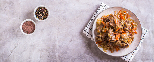 Stewed beef oxtail with wine and vegetables on a plate on the table top view web banner
