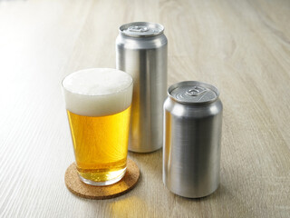 机の上の缶ビールをグラスに注ぐ
