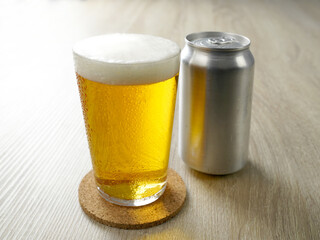 机の上の缶ビールをグラスに注ぐ