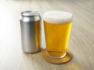 机の上の缶ビールをグラスに注ぐ