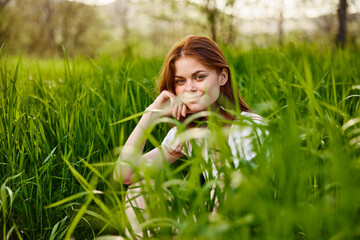 adorable woman sitting in nature resting in tall grass