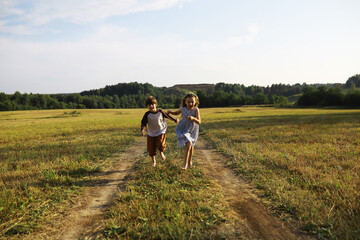 Children walk in the summer in nature. Child on a sunny spring morning in the park. Traveling with children.