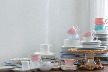 pink, white abd blue  cutlery on a wooden table against a white wall