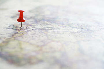 Travel concept. Map and needle with a marked place. Compass point on the map and routes.