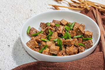 Fried teriyaki Tofu with scallions and sesame seeds. Healthy vegan meatless meal rich in protein