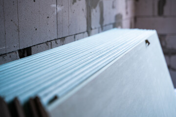 A lot of sheets of moisture-resistant drywall close-up at a construction site. Universal facing...